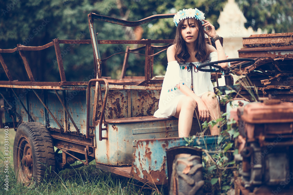 Young Woman Sitting On Abandoned Vehicle At Field