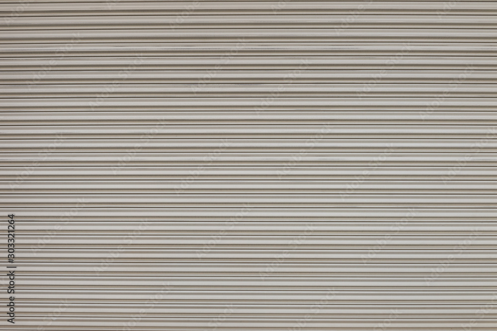 A closeup shot of automatic metal roller door used in factory, storage, garage, and industrial warehouse. The corrugated and foldable metal sheet offer space saving and provide urban and rustic feel A closeup shot of automatic metal roller door used in factory, storage, garage, and industrial warehouse. The corrugated and foldable metal sheet offer space saving and provide urban and rustic feel