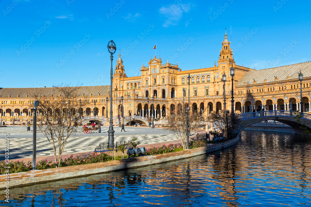 North wing of the building and river at the Spain Square (Plaza de Espana) in Seville (Sevilla) city, Andalusia, Spain. Example of Renaissance revival architecture. Bright Sunny day