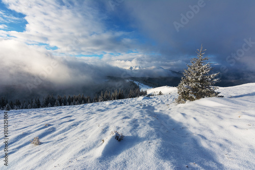 Winter landscape with the sunrise in the Ukrainian Carpathian Mountains, with fogs and beautiful colors.