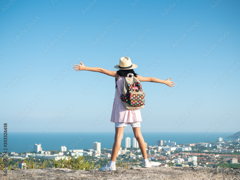 Back of girl raising hands on the top of city view, lifestyle concept.