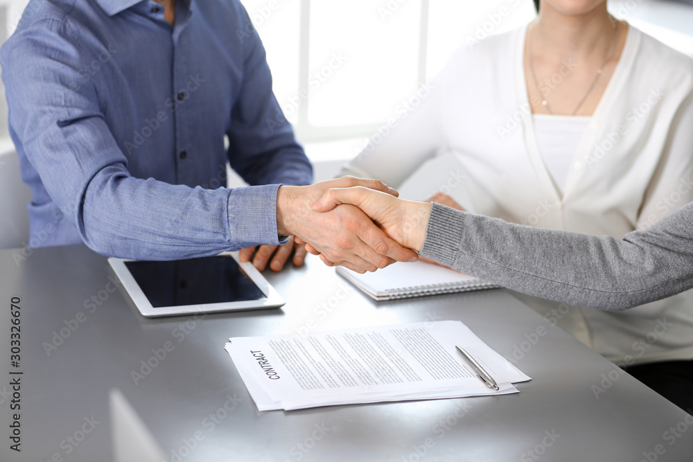 Group of business people shaking hands after discussing questions at meeting in modern office. Handshake close-up. Teamwork, partnership and agreement in business concept Group of business people shaking hands after discussing questions at meeting in modern office. Handshake close-up. Teamwork, partnership and agreement in business concept