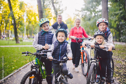 Theme family sports vacation in park in nature. big friendly Caucasian family of six people mountain bike riding in forest. Children brothers and sister stand on the background of parents in a row © Elizaveta