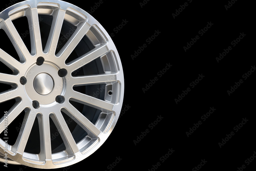 new vehicle rims made from aluminum alloy, multi-spoke silver wheel, close-up on a black background, copy space.