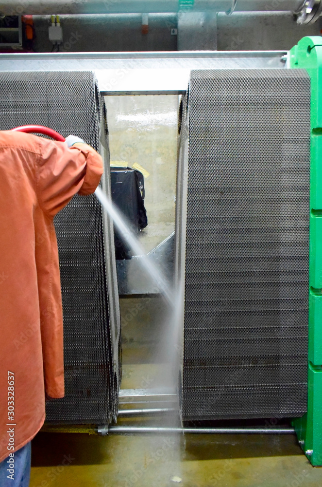 Φωτογραφία Technical worker cleaning Heat exchanger plate of the water cooling system on power plant