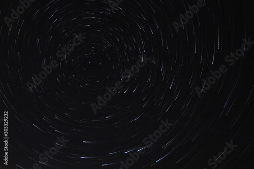 Long exposure starry sky, twisted tracks of stars.