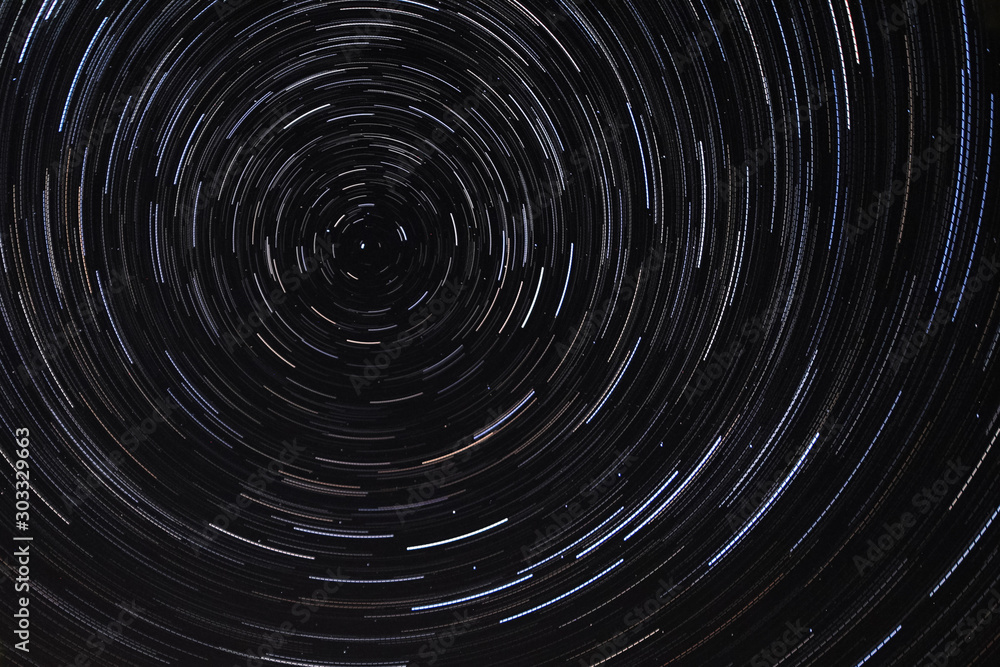 Long exposure starry sky, twisted tracks of stars.