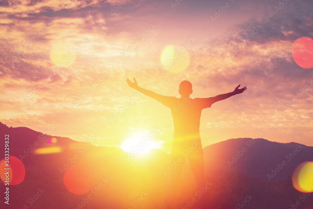 Copy space of man rise hand up on top of mountain and sunset sky abstract background.