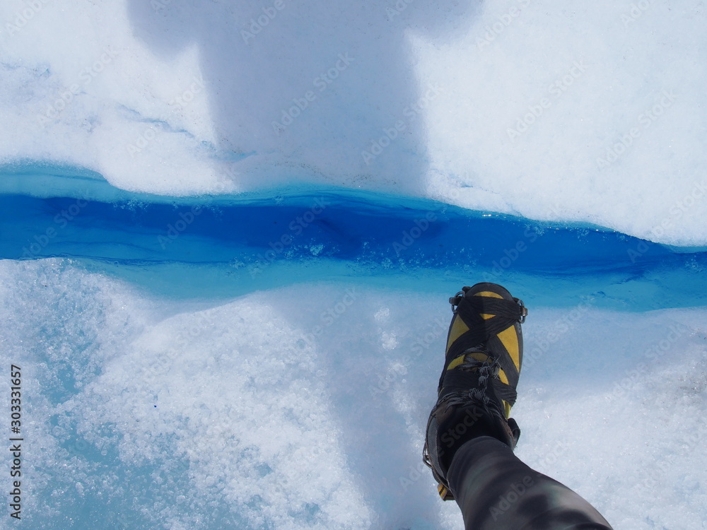 Φωτογραφία A closeup of a beautiful clear blue glacier with tourist's feet, Perito Moreno G