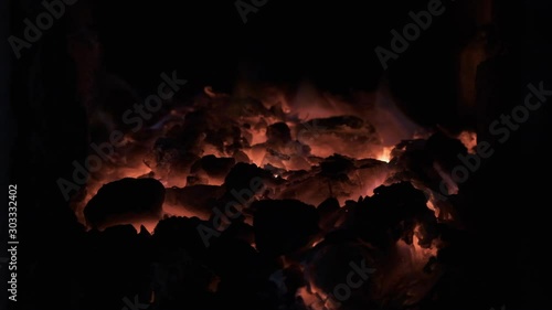 Slow motion. Burning coal in the stove. Live coal, embers, glowing coals, abstract background.