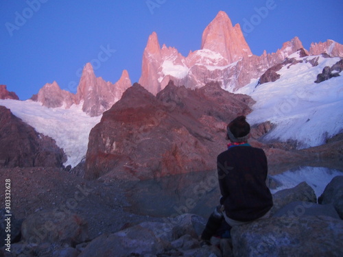A woman hiker gazing at Mount Fitz Roy that begins to be tinted red by the sunrise, Precious scenery created by nature, Los Glaciares National Park near El Chalten, Patagonia, Argentina © Mithrax