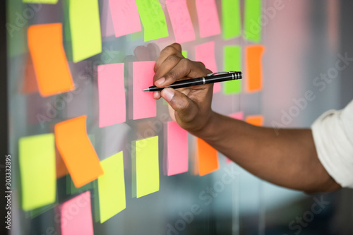Close up african american manager writing notes on kanban board. photo