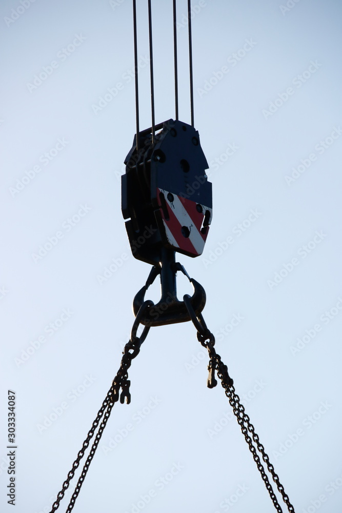 Haken an einem Baukran, zur Aufnahme von schweren Gewichten mit einer Kette Haken an einem Baukran, zur Aufnahme von schweren Gewichten mit einer Kette
