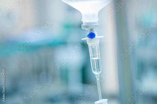 Intravenous therapy iv infusion set and bottle on a pole. Liquid saline is slowly dripping drops of drugs, medicine or antibiotic therapy and surgery recovery in a hospital or clinic