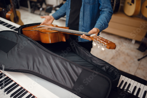 Guitarist puts guitar in the case, music store