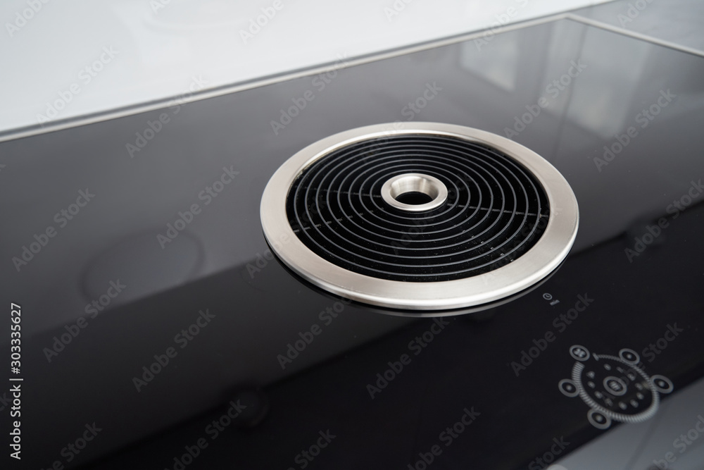 Φωτογραφία Modern induction cooker with a black glass surface and integrated hood in the ki