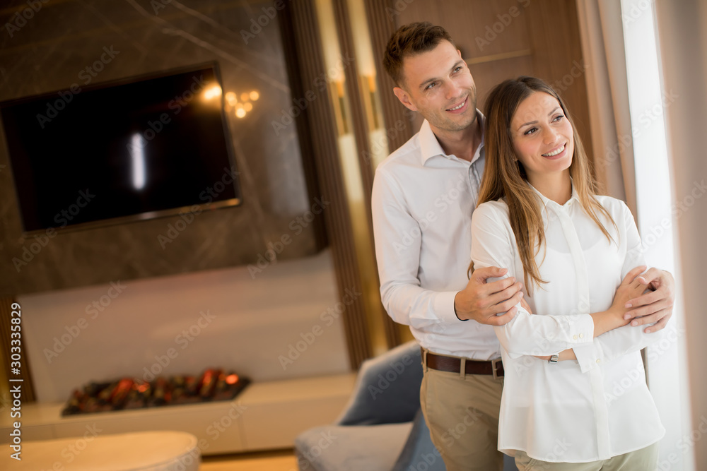 Couple embracing standing in living room of a contemporary apartment Couple embracing standing in living room of a contemporary apartment