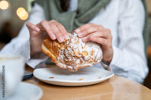 woman eating freash baken croissant photo
