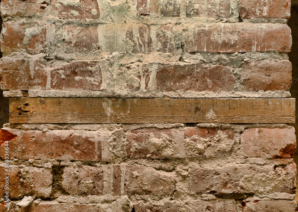 Fototapeta premium Old brick wall with wooden mortgage.