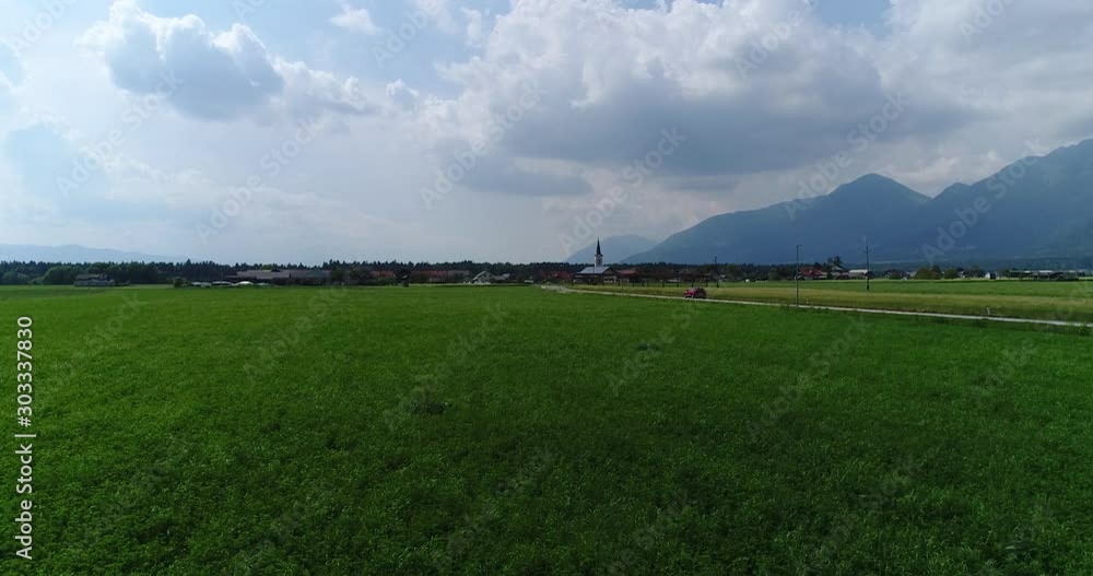 Drone aerial forward flying over field with traffic on right side Drone aerial forward flying over field with traffic on right side