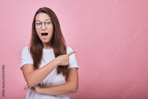 Cute lady shows forefingers to the side and her mouse open