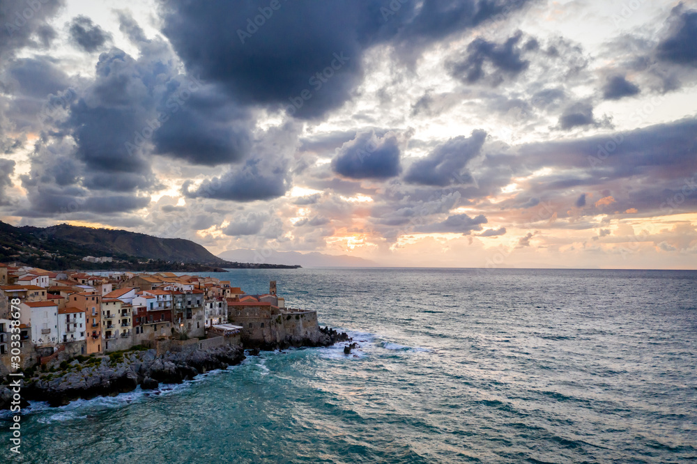 Cefalu Sicily night town aerial view with the city lights and sunset sky . Italy, Tyrrhenian Sea