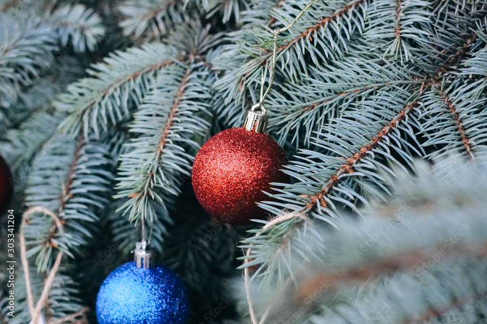 Christmas toy on the branches of a New Year tree. Christmas tree decorated with a festive ball and wooden toys