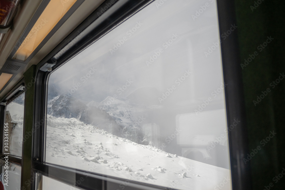 Beautiful window view of snow mountain with foggy for background with copy space, Jungfrau, Switzerland Beautiful window view of snow mountain with foggy for background with copy space, Jungfrau, Switzerland