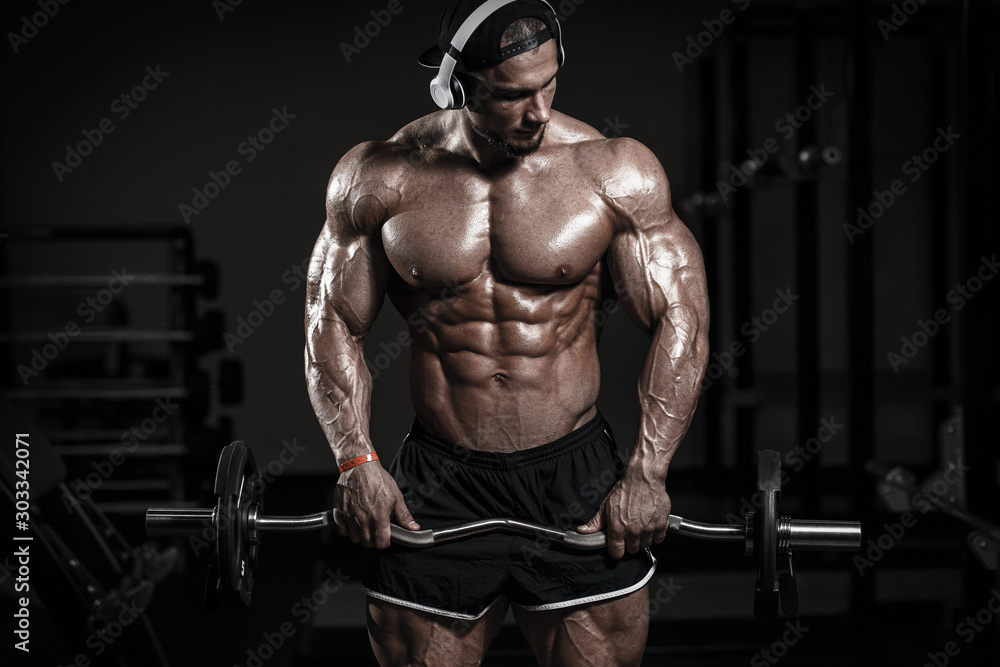 Muscular athletic bodybuilder fitness model training arms with