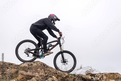 Mountain biker rides a bicycle on the rocks  extreme sport.