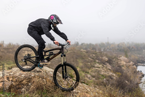 Mountain biker rides a bicycle on the rocks, extreme sport.
