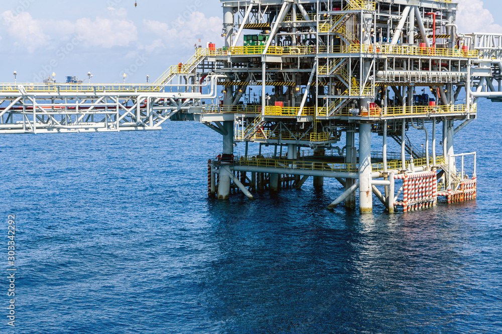 Offshore production platform at oil field with bridge connection to adjacent riser platform Offshore production platform at oil field with bridge connection to adjacent riser platform