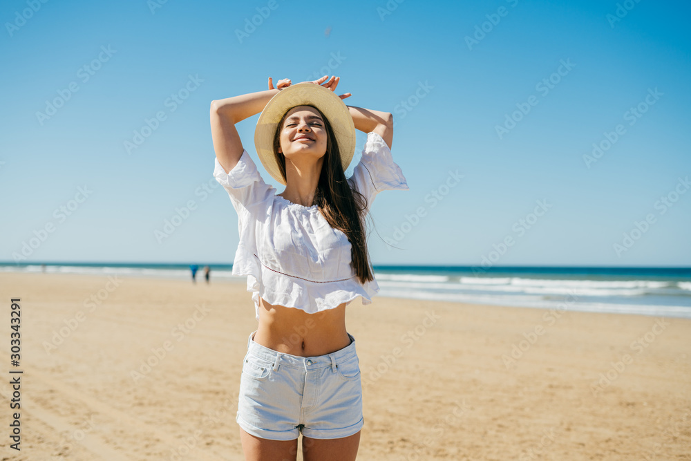Ταπετσαρία spa girl in full bliss stretches on the beach, throwing his head up in a hat and