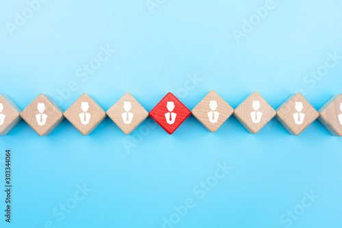 Leadership concept, Red wooden block with businessman icon on blue background. copy space