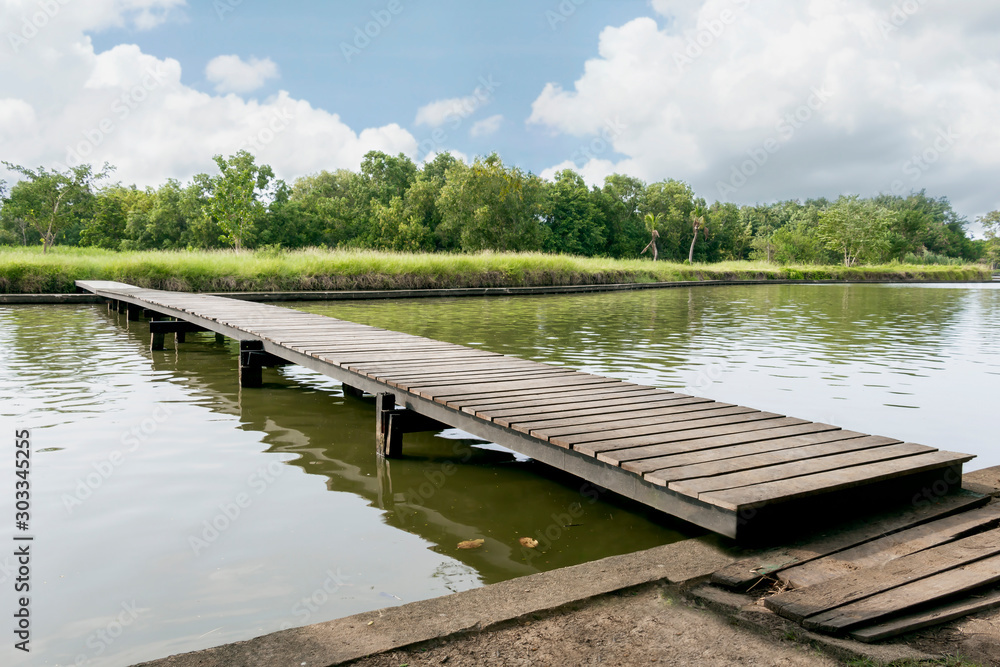 Wood bridge on the sea which has walk way for travel tourism with tropical forest island and sunshine with sky beautiful background for holiday destination for tourists.