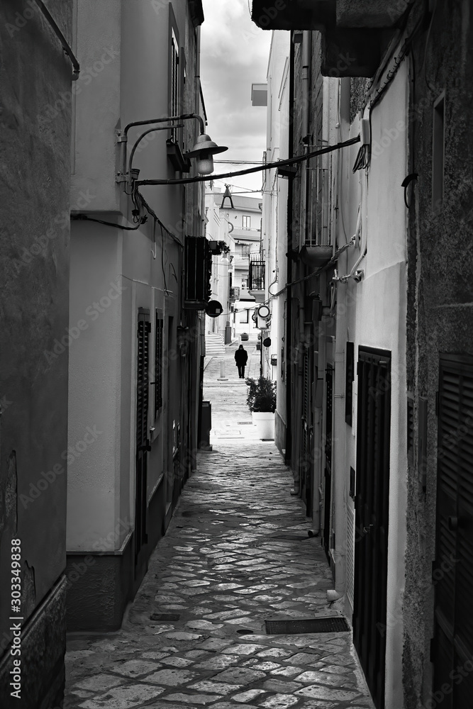 Evening winter on the streets of Polignano a Mare Old Town, Bari Province, Puglia region, southern Italy. Black and white image.