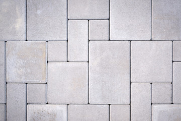 Laying gray concrete paving stones on house courtyard