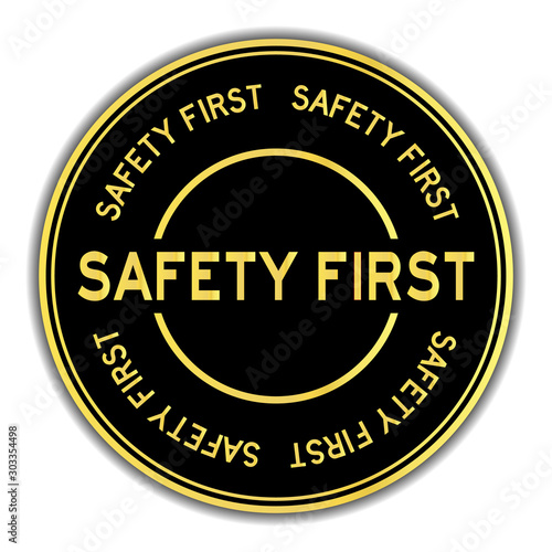 Gold color safety first word round sticker on white background