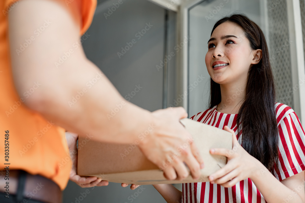 Delivery man giving a cardboard box to young woman. Delivery man giving a cardboard box to young woman.