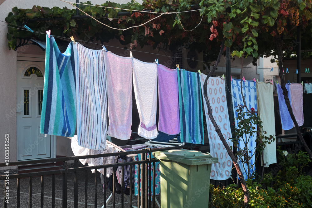 Washing line with drying clothes in outdoor. Clothes hanging on washing line.  Stock Photo