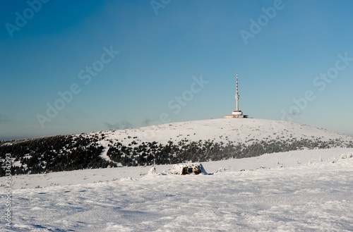 Winter trail in Jeseniky mountains in zhe Czechia during nice winter day with clear sky. Wiew of Praded hill with communication tower. Skiers and trees covered in snow. Eastern Sudetes, Praded hill 