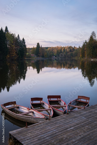 four boats on lake on an evening in fall