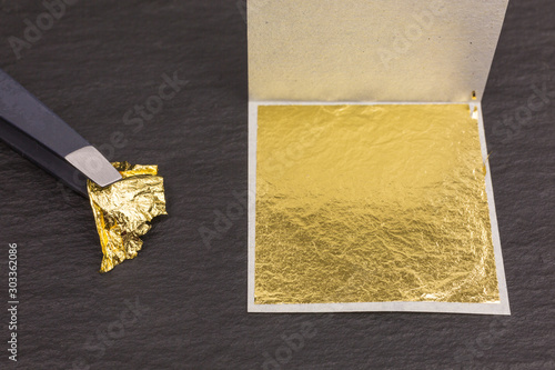 piece of edible gold leaf held by tweezers