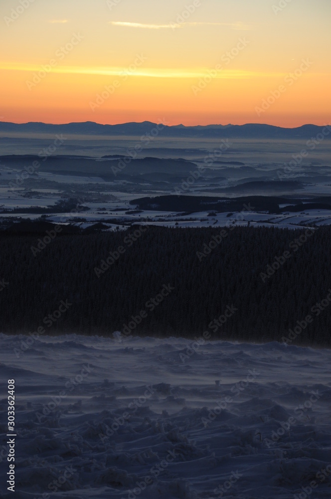 Fotografie Sunrise in snow covered Jeseniky mountains in Czechia during nice winter with fog and clear sky