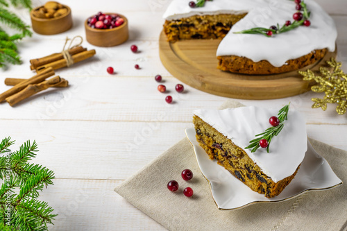 Traditional Christmas cake with fruits, nuts and white glaze with Christmas decorations. White background