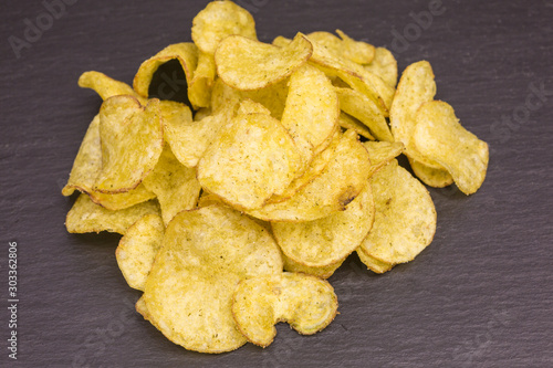 heap of potato crisps with basil and cheese flavor