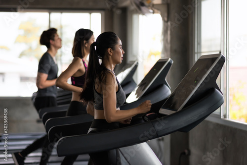 Group of friends run treadmills in gym