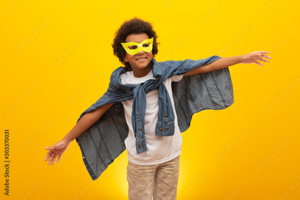 Portrait of a young, mixed race boy dressed as a superhero. Black baby in super hero costume. The winner and success concept. - obrazy, fototapety, plakaty 