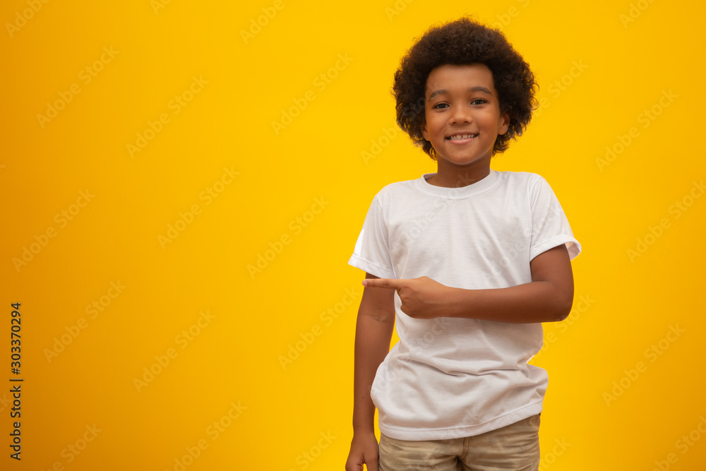 African American boy with black power hair on yellow background. Smiling black kid with a black power hair. Black boy with a black power hair. African descent. - obrazy, fototapety, plakaty 