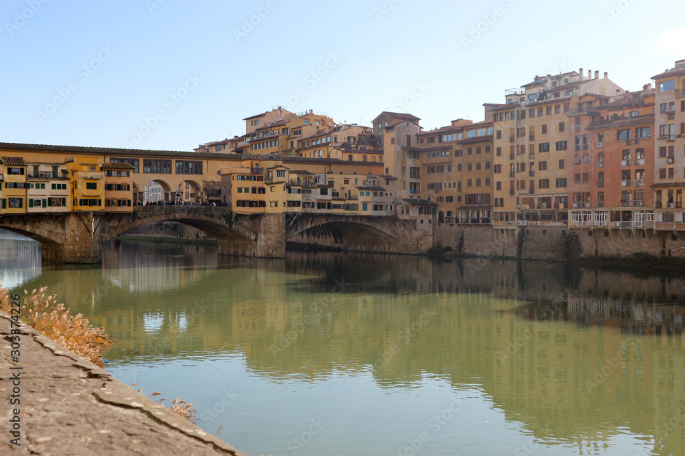 View to ponte vecchio in florence and its reflection in Arno river